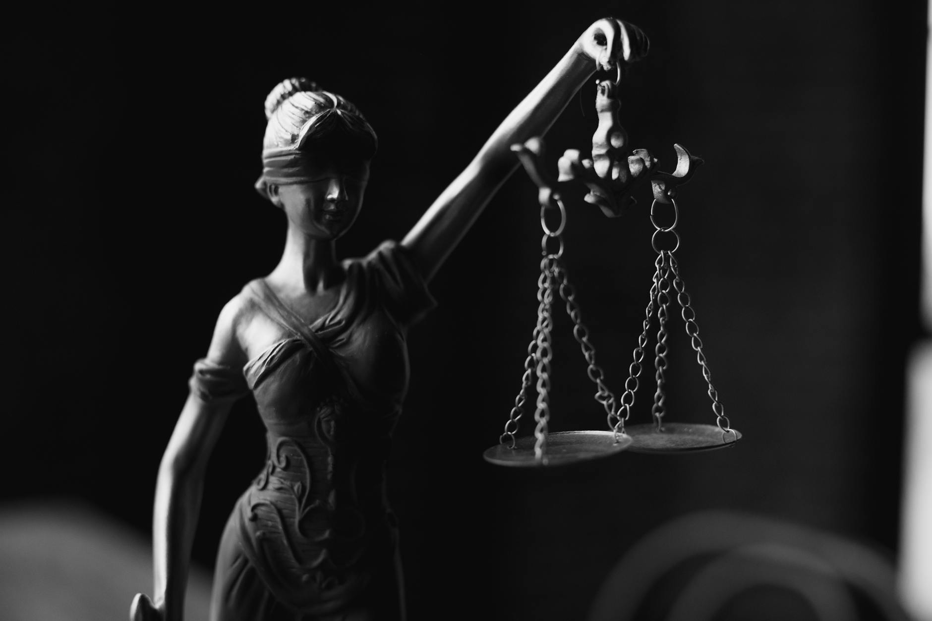 a grayscale of a lady justice figurine